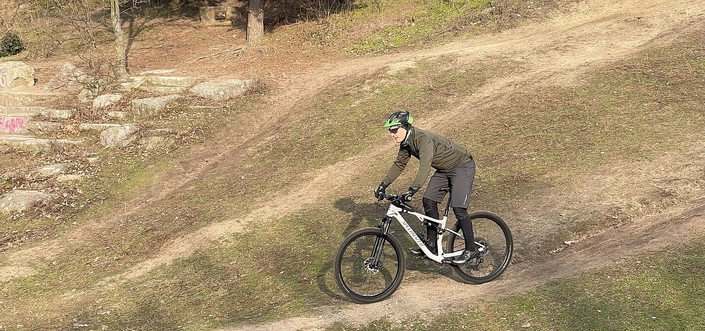 Training in sonnigem Winterwetter Mountainbiker auf einer Abfahrt im Gelände bei sonnigem Winterwetter.